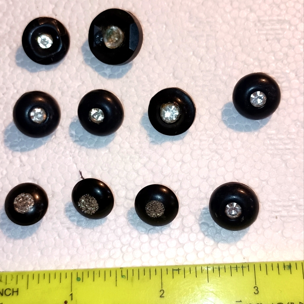 Vintage black plastic buttons with fake diamond like stone in center.